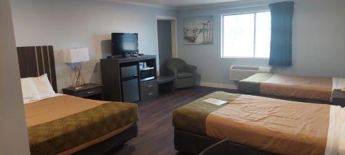 卡尔卡斯卡Rodeway Inn Kalkaska的酒店客房设有两张床和电视。