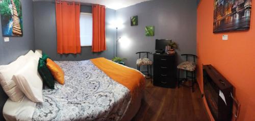 尼亚加拉瀑布Gracies Fallsview Getaway的一间卧室配有一张带橙色墙壁和窗户的床