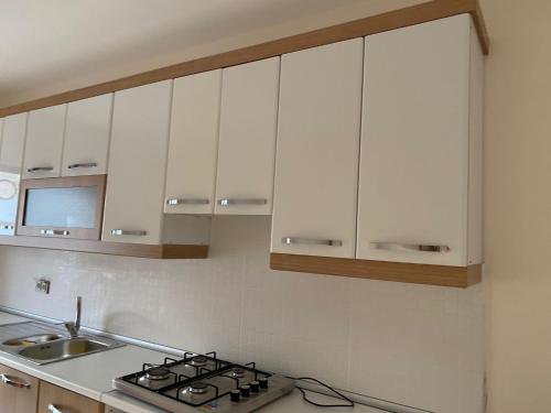 萨卡里亚Apartment at a Resort by the Black Sea的厨房配有白色橱柜和炉灶。
