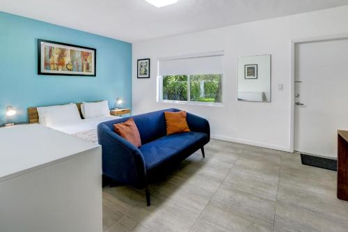 迈阿密Cottages El Portal的客厅配有蓝色的沙发和床。