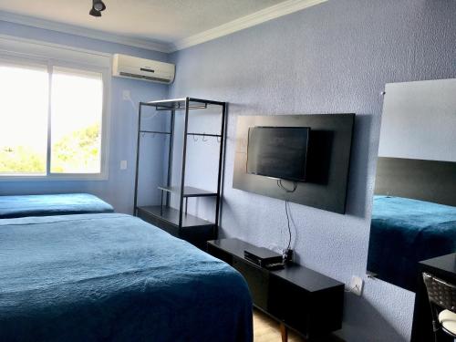 弗洛里亚诺波利斯Residencial Gralha Azul的一间酒店客房,设有两张床和电视