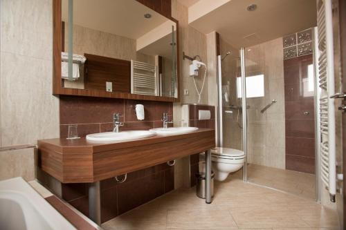 佩奇马卡运动及健身酒店的浴室配有2个盥洗盆、卫生间和淋浴。