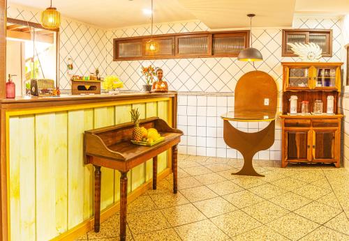 塞尔苏拉穆斯州长镇Pousada Casa do Oscar的厨房配有一张桌子,上面放着一碗水果