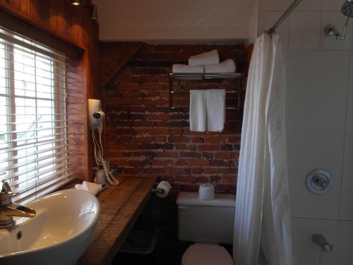 魁北克市河滨大道马努瓦尔酒店的一间带白色水槽和砖墙的浴室