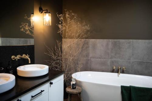 OatlandsRaffah House的浴室配有两个盥洗盆和浴缸。