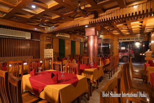 达卡Hotel Shalimar Motijheel - Centre of City的一间在房间内配有桌椅的餐厅