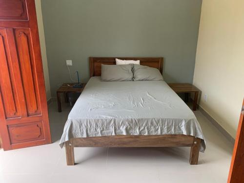 格拉纳达apartamentos Casa Amarilla的一张床位,房间设有两个床头柜和一张四柱床