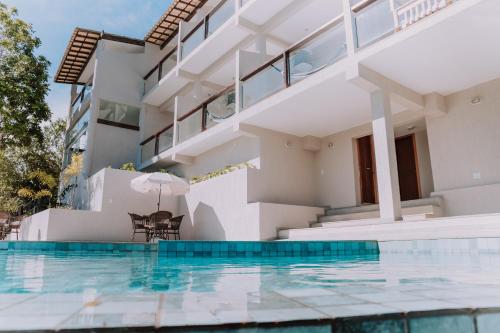 布希奥斯Pousada Peninsula de Buzios的一座带游泳池和房子的别墅