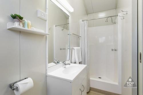 贡迪温迪谷底温蒂假日公园的白色的浴室设有水槽和淋浴。