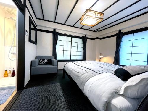 野沢Nozawa Onsen BASECAMP的一间卧室配有一张大床和一把椅子