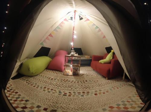 阿苏市阿蘇び心 Asobi Gokoro的一间带沙发和桌子的帐篷的房间