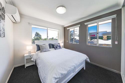 布里斯班Calamvale Business or Holiday like Home的卧室配有白色的床和2扇窗户。