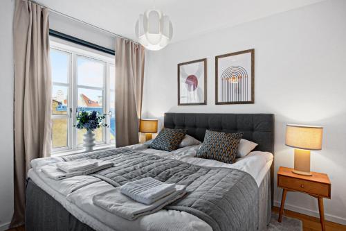 哥本哈根Sanders Haven - Lovely Two-Bedroom Apartment In Historical Copenhagen的一间卧室设有一张大床和一个窗户。