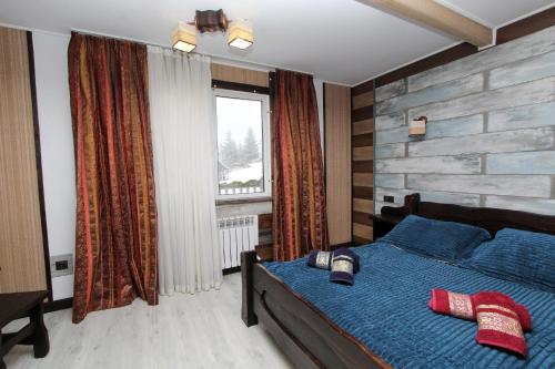 亚布卢尼齐亚Nord Cottage的一间卧室设有蓝色的床和窗户。