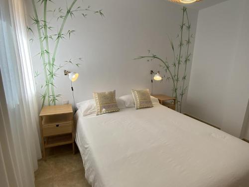 拉雷斯廷加Vivienda vacacional sur de europa b 1 3的卧室配有白色的床和2种植物