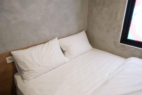 BinongM Cabin Karawaci的小房间配有一张带白色枕头的床