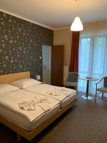 哈卡尼Hotel Korona的卧室配有一张床和一张桌子及椅子