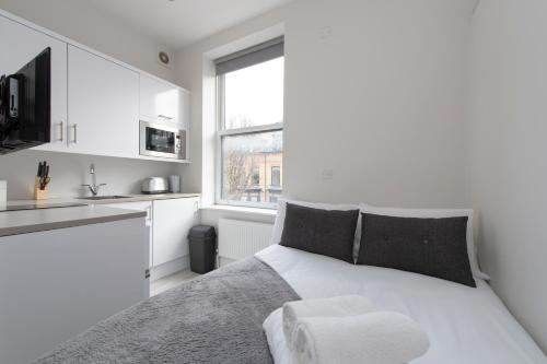 伦敦Fabulous Apartment in Superb location的一间白色卧室,配有床和厨房