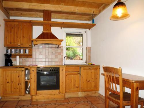 霍恩贝格Holiday Home Sonnenschein by Interhome的厨房配有木制橱柜、桌子和窗户。