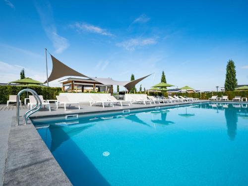 贝梅伦Holiday Home Green Resort Mooi Bemelen by Interhome的度假村旁的游泳池,带白色躺椅