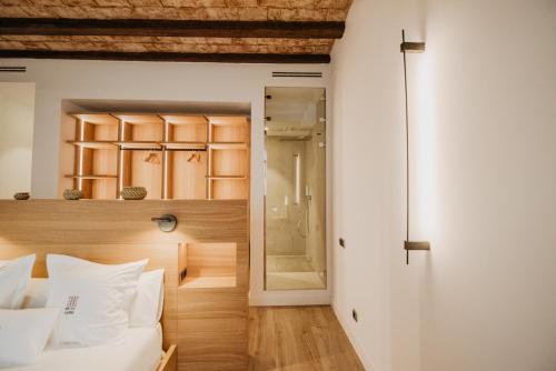 特拉萨Petit Luxe St. Pere的一间卧室设有一张床和一个步入式淋浴间。