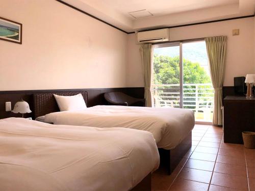 IbarumaPine Shima Resort Coral Fish的酒店客房设有两张床和窗户。