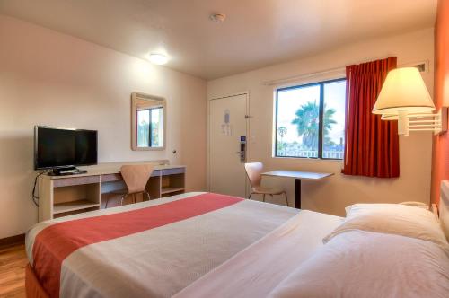 奥欣赛德欧申赛德6号汽车旅馆的酒店客房配有一张床、一张书桌和一台电视。