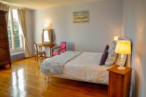 奥登河畔的布雷特维尔Maison de vacances _ Le Bas Manoir的卧室配有一张床和一张桌子及椅子