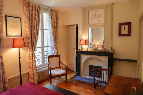 奥登河畔的布雷特维尔Maison de vacances _ Le Bas Manoir的客厅设有壁炉和桌子