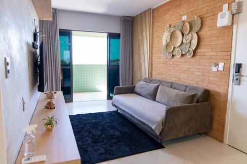 普拉亚弗朗西丝Apto 2 suites com elevador no Frances -Adm Nutelss的带沙发和砖墙的客厅