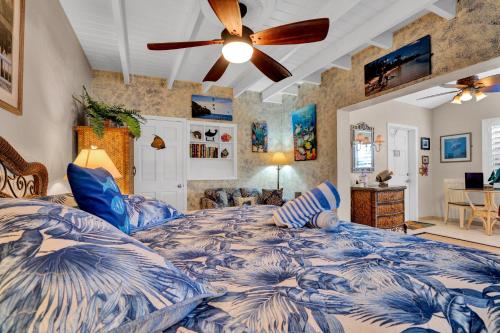 基拉戈Island Bay Resort的卧室配有蓝色和白色的床和吊扇