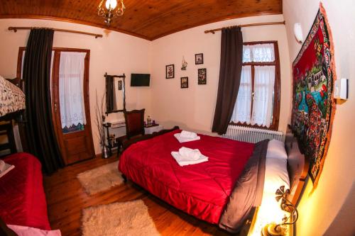 ArkochórionMylos的一间在房间内配有红色床的卧室