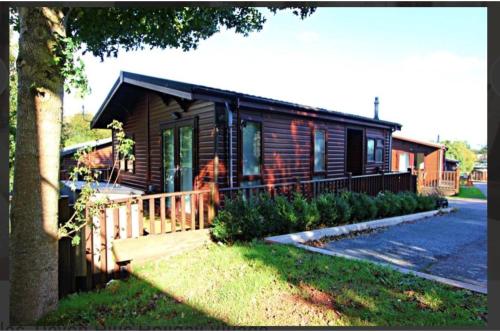 佩恩顿Brambles Holiday Lodges的小木屋设有门廊和房屋