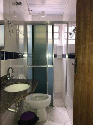 乌巴图巴Hotel Pousada Nosso Cantinho的浴室配有卫生间、盥洗盆和淋浴。