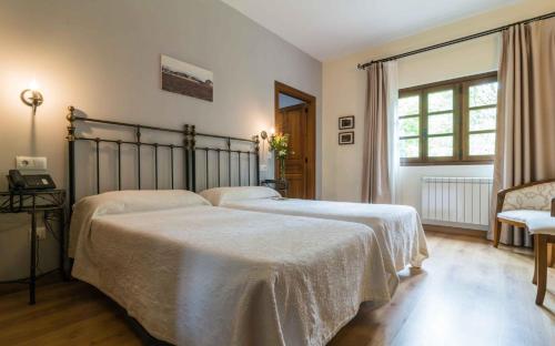 San SalvadorAlesga Hotel Rural - Valles del Oso -Asturias的一间卧室设有两张床和窗户。