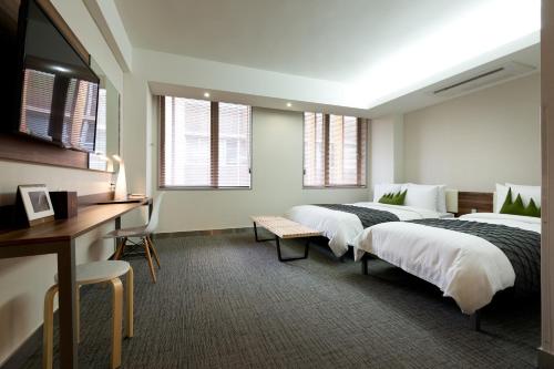首尔地铁明洞酒店的酒店客房设有两张床、一张书桌和窗户。