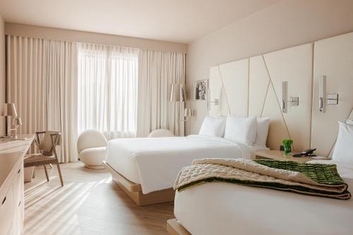 奥兰多ette luxury hotel & spa的白色的酒店客房 - 带两张床和书桌