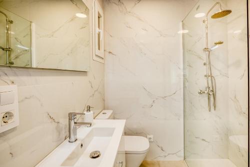 罗萨斯Apartament Roses Vista Mar的白色的浴室设有水槽和淋浴。