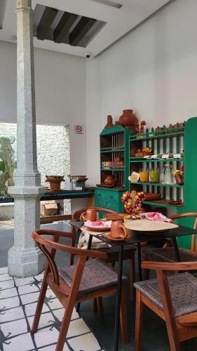 瓦哈卡市Casa Naila Hotel Boutique的厨房配有桌椅和绿色架子