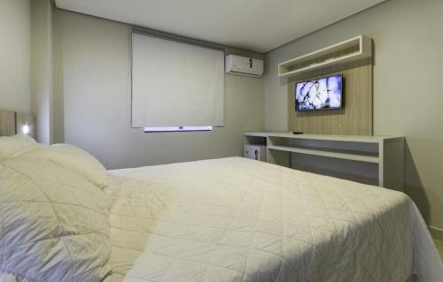 大坎普WR Confort Hotel Campo Grande的一间卧室配有一张床和一台平面电视
