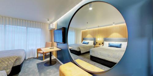 旺阿雷旺阿雷会议中心卓越酒店的酒店客房,设有两张床和镜子