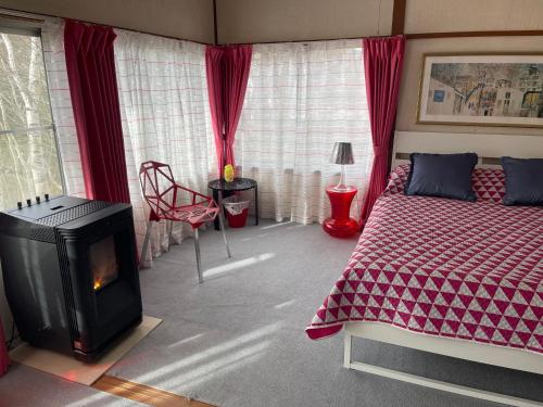 汤泽町Naeba Ski Resort - Cottage away from usual life的一间卧室设有一张床和一个壁炉。