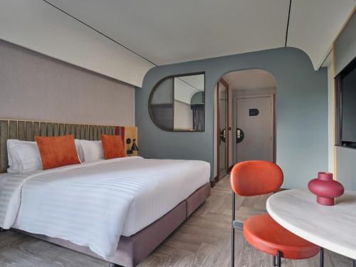 曼谷UHG 安努季节酒店的一间卧室配有一张大床和一张桌子