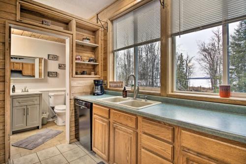 大急流城Quiet Lakefront Grand Rapids Cabin on 5 Acres的厨房配有水槽、卫生间和窗户。