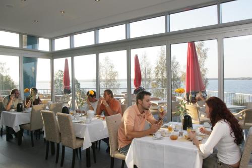森夫滕贝格森夫滕贝格湖海滩酒店的一群坐在餐厅桌子上的人