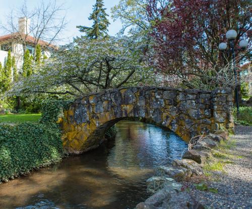 胡德里弗Columbia Gorge Hotel & Spa的公园里一条河上的石桥