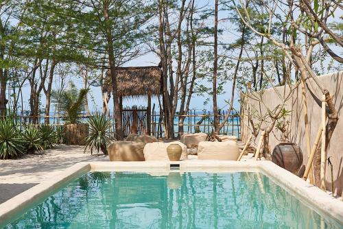 吉利美诺吉利美诺岛屿别墅的一座树木繁茂的庭院内的游泳池