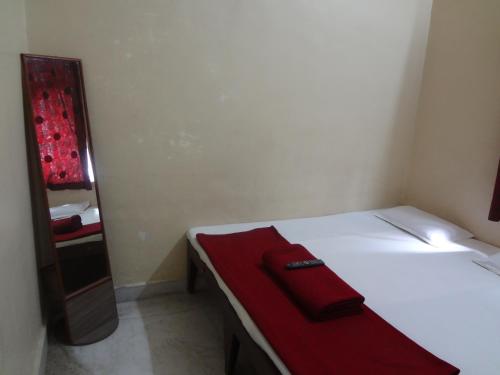浦那雷玛迪尔酒店的一间卧室配有一张带红色毛巾的床