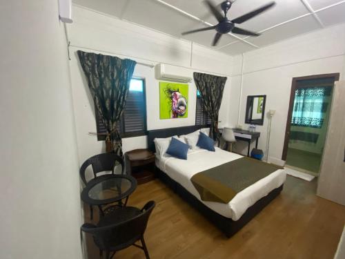 乔治市BoraBora Beach Guesthouse Penang的一间卧室配有一张床和吊扇