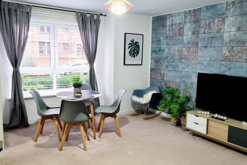 格拉斯哥Stylish 2 bedroom Apartment / FREE Gated Parking的客厅配有桌椅和电视。